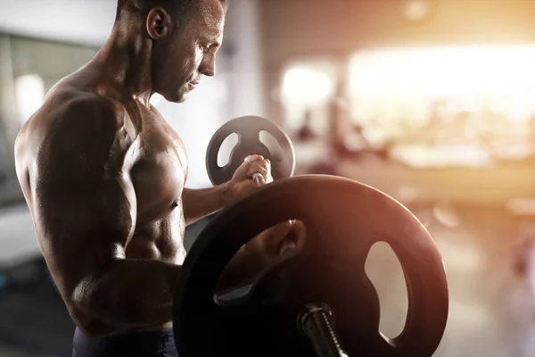 Athletic man training biceps at the gym — Stock Photo, Image