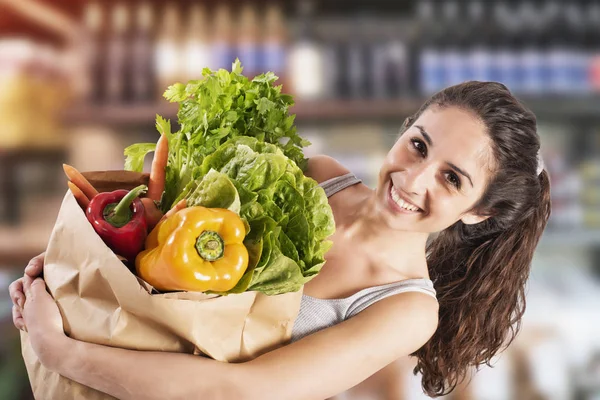 Bio conceito de compras com a menina no supermercado com — Fotografia de Stock