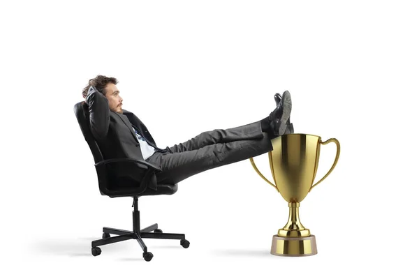 Gewinner Geschäftsmann entspannt bei einem goldenen Pokal — Stockfoto