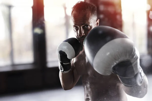 Homem faz exercícios de boxe no ginásio — Fotografia de Stock