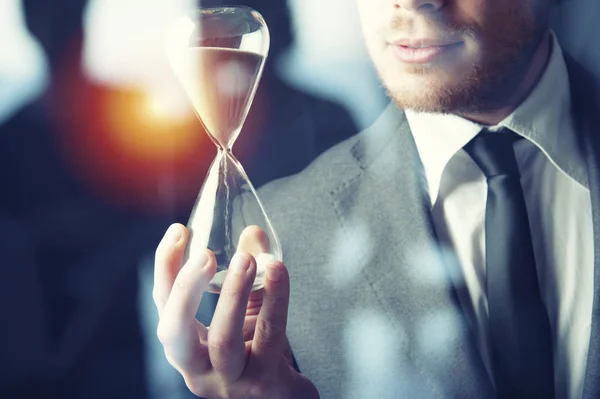 Businessman holding a hourglass. Concept of deadline in business — Stock Photo, Image