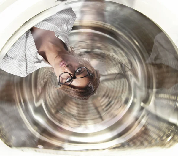 Empresária confusa tem tonturas dentro de uma máquina de lavar roupa. Conceito de estresse e excesso de trabalho — Fotografia de Stock
