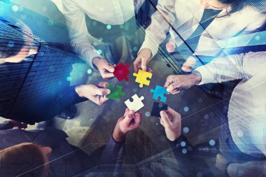 Business people join puzzle pieces in office. Concept of teamwork and partnership. double exposure with light effects clipart