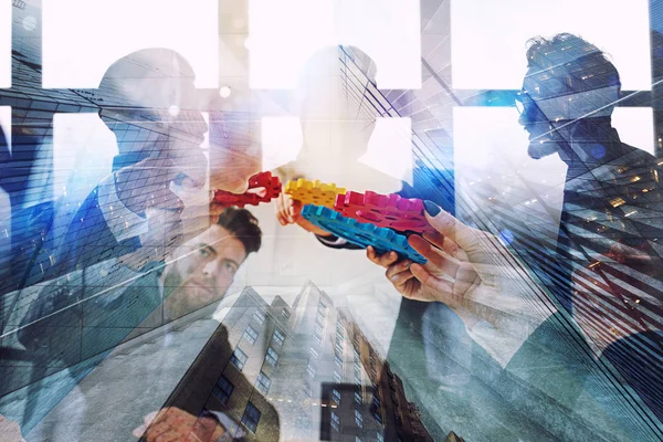Working group of businessmen find the agreement by holding a piece of gear in hand. concept of teamwork and business partnership. double exposure — Stock Photo, Image
