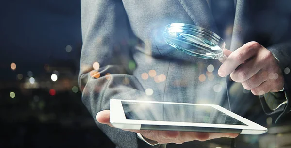 Biznesmen bada tablet ze szkłem powiększającym. Pojęcie bezpieczeństwa internetu — Zdjęcie stockowe