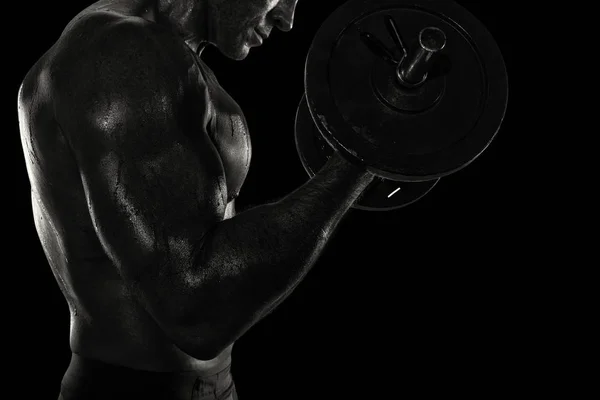 Hombre atlético entrenando bíceps en el gimnasio. efecto blanco y negro — Foto de Stock