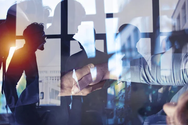 A apertar as mãos de um empresário no escritório. conceito de trabalho em equipe e parceria. Dupla exposição — Fotografia de Stock