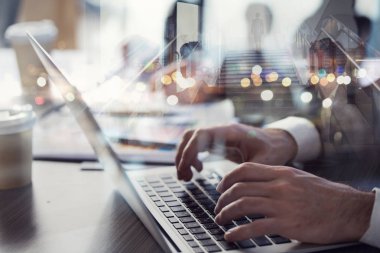 İş adamı ile laptop ön planda ofiste çalışıyor. Takım çalışması ve ortaklık kavramı. Çift Pozlama