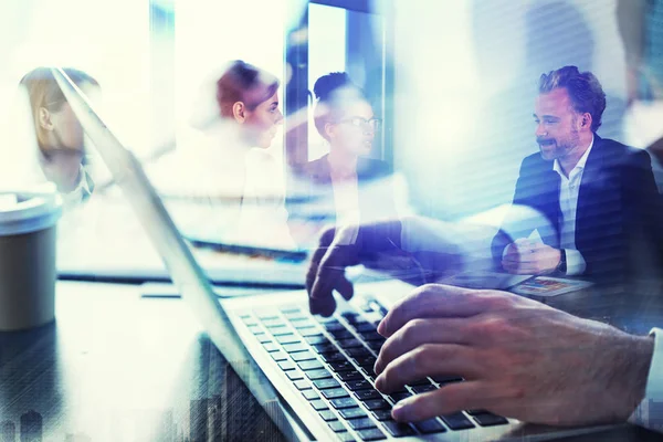 Uomo d'affari lavora in ufficio con il computer portatile in primo piano. Concetto di lavoro di squadra e partenariato. doppia esposizione — Foto Stock