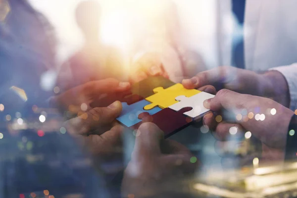 Zakenmensen voegen zich bij puzzelstukjes op kantoor. Concept van teamwork en partnerschap. dubbele blootstelling met lichteffecten — Stockfoto