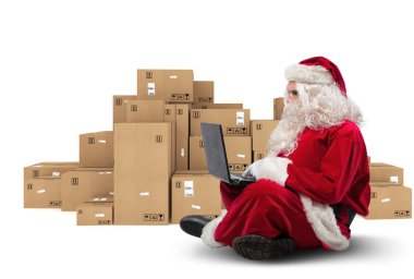 Teknolojik Noel Baba laptop ile oturan e-ticaret ile Noel hediyeleri satın alır.