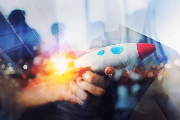 Businessman launches his startup company. Hand holding a wooden rocket. double exposure with light effects — Stock Photo, Image