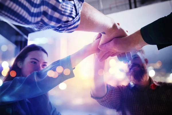 A apertar as mãos de um empresário no escritório. conceito de trabalho em equipe e parceria. dupla exposição com efeitos de luz — Fotografia de Stock