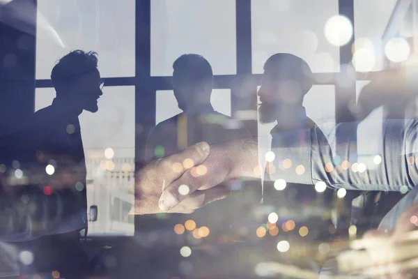 A apertar as mãos de um empresário no escritório. conceito de trabalho em equipe e parceria. Dupla exposição — Fotografia de Stock