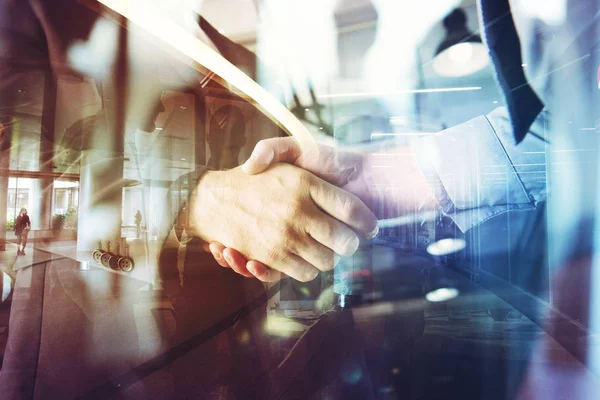 Handshaking business person in the office. concept of teamwork and partnership. double exposure — Stock Photo, Image