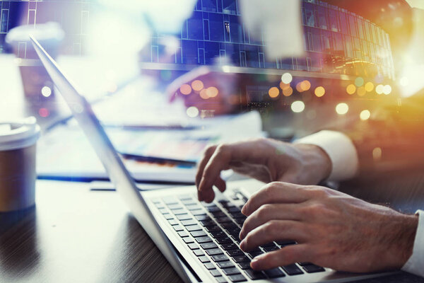 Деловой человек работает в офисе с ноутбуком на переднем плане. Концепция командной работы и партнерства. двойное воздействие
