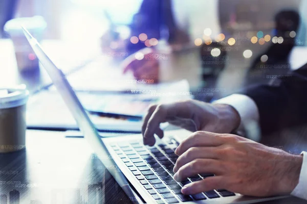 El hombre de negocios trabaja en la oficina con el portátil en primer plano. Concepto de trabajo en equipo y asociación. doble exposición — Foto de Stock