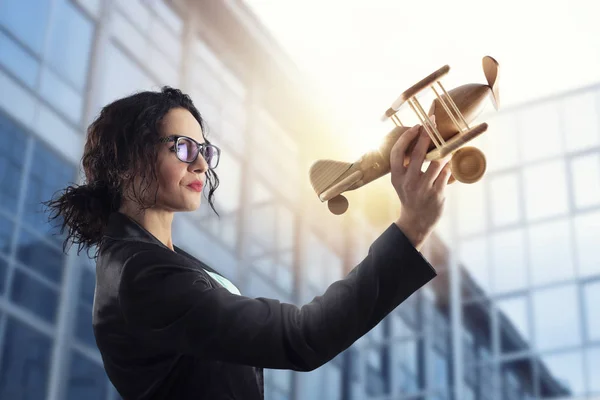 Geschäftsfrau spielt mit einem Spielzeugflugzeug. Konzept der Unternehmensgründung und des Unternehmenserfolgs — Stockfoto