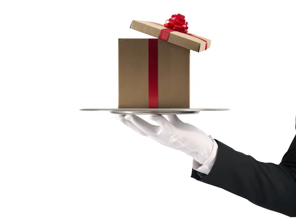 Σερβιτόρος κατέχει ένα χριστουγεννιάτικο δώρο σε έναν δίσκο. Απομονωμένα σε λευκό φόντο — Φωτογραφία Αρχείου