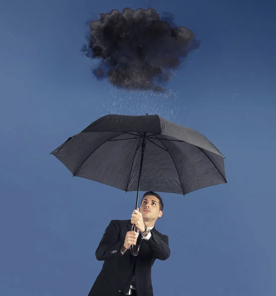 Businessman with umbrella and a black cloud with rain. Concept of crisis and financial trouble Stock Picture