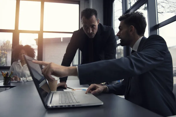 Mensen uit het bedrijfsleven werken samen in kantoor met een laptop. Concept van teamwerk en partnerschap — Stockfoto