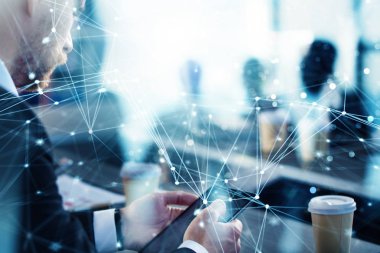 İş adamı ön planda tablet ile ofiste çalışıyor. Takım çalışması ve ortaklık kavramı. Ağ etkileri ile çift pozlama