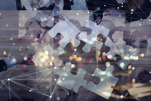 Business people join puzzle pieces in office. Concept of teamwork and partnership. double exposure with internet network effects — Stock Photo, Image