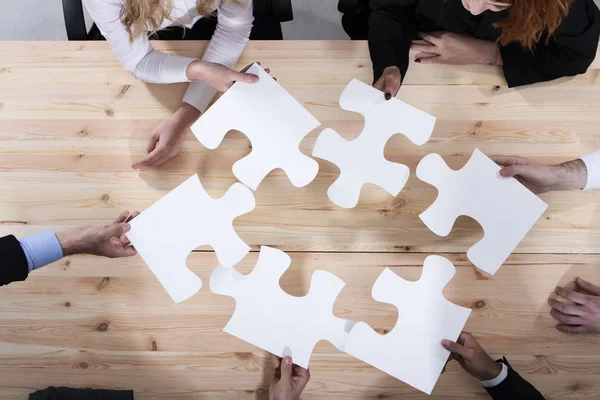 Business people work together to build a puzzle. Concept of teamwork, partnership, integration and startup — 스톡 사진