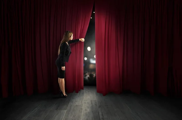 Donna aprire tende rosse del palcoscenico teatrale — Foto Stock