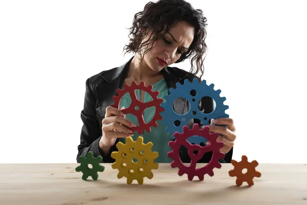 Mujer de negocios trata de conectar piezas de engranajes. Concepto de trabajo en equipo, asociación e integración — Foto de Stock