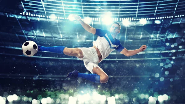 Футбольный нападающий бьет по мячу акробатическим ударом в воздух на стадионе — стоковое фото