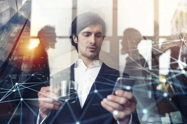 El hombre de negocios trabaja con su smartphone en la oficina. doble exposición . —  Fotos de Stock