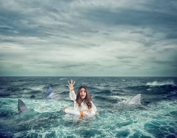 Businesswoman with lifebelt surrounded by sharks asks help — Stock Photo, Image