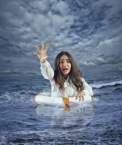 Zakenvrouw in de oceaan met reddingsboei vraagt hulp tijdens een storm — Stockfoto