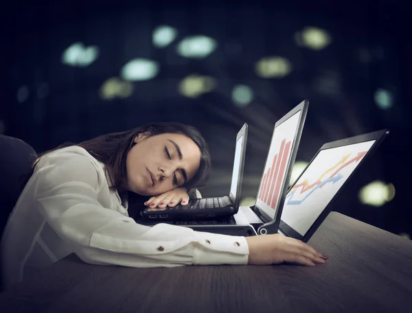 Trabalhadora adormece enquanto trabalha simultaneamente em três laptops — Fotografia de Stock