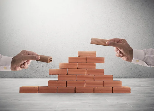 Affärsman sätter en tegel för att bygga en mur. Begreppet nya affärer, partnerskap, integration och start — Stockfoto