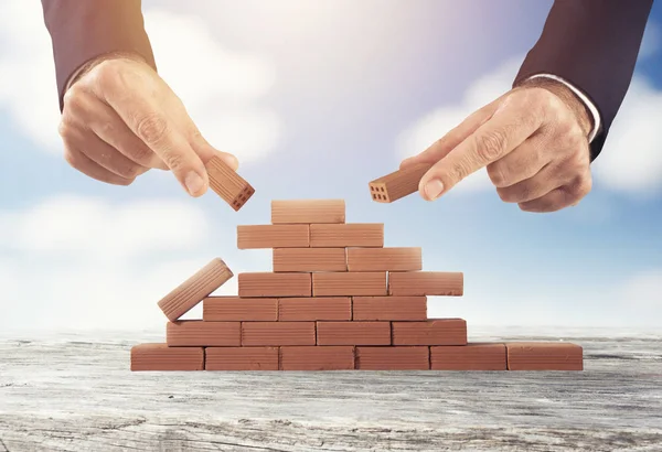 Επιχειρηματίας βάζει ένα τούβλο για να χτίσει ένα τείχος. Έννοια της νέας επιχείρησης, εταιρική σχέση, ένταξη και εκκίνησης — Φωτογραφία Αρχείου