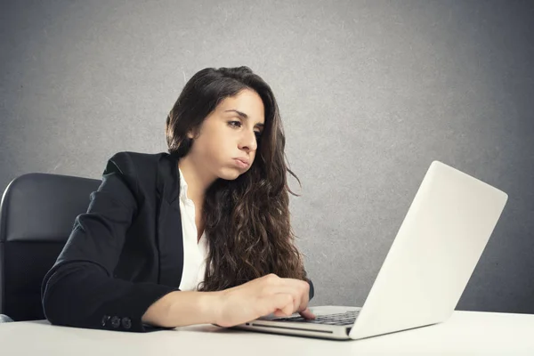 Bored woman snorts in the office while working on the laptop — Stock Photo, Image