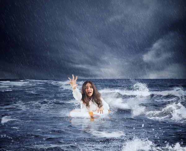 Businesswoman in the ocean with lifebelt asks help during a storm — Stock Photo, Image