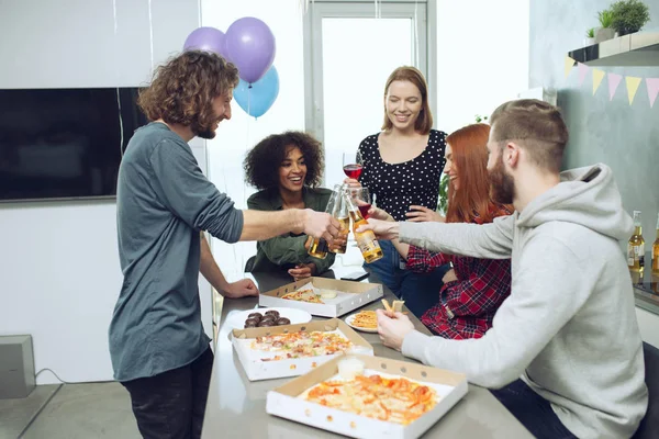 Fiatal barátok pizzát esznek és sört isznak, jól érzik magukat otthon.. — Stock Fotó