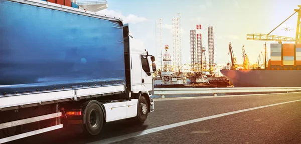 Caminhão que viaja rápido para um porto comercial ao pôr do sol — Fotografia de Stock