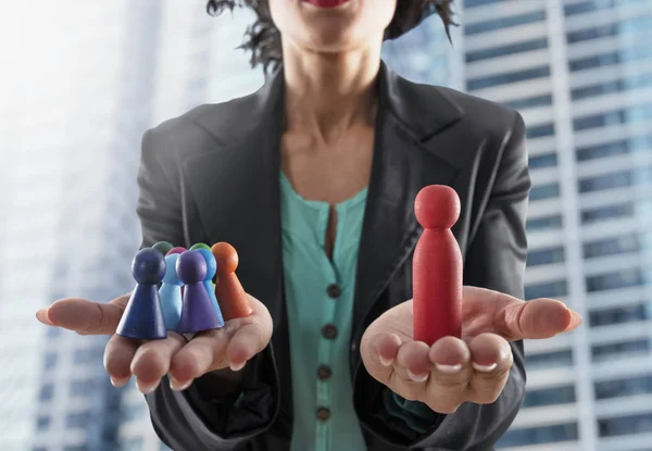 Zakenvrouw houdt houten speelgoed gevormd als persoon. Concept van Business teamwork en leiderschap — Stockfoto