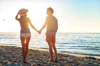 Plajda gündoğumu sırasında çiftler