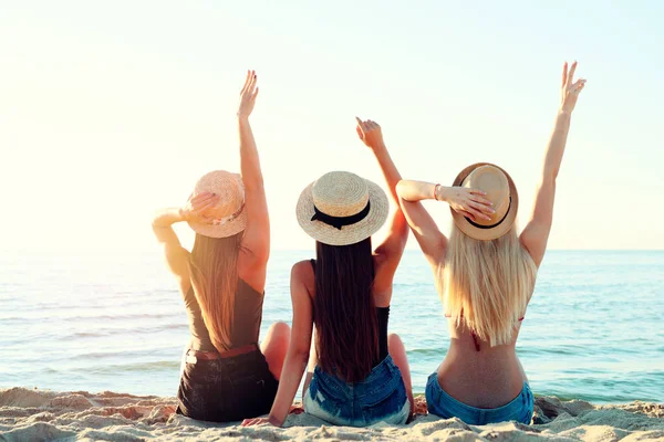 Skupina šťastných dívek, které se při úsvitu baví na mořské pláži — Stock fotografie
