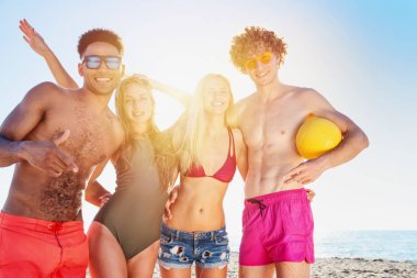 Plaj voleybolu kumsalda oynarken arkadaş grubu