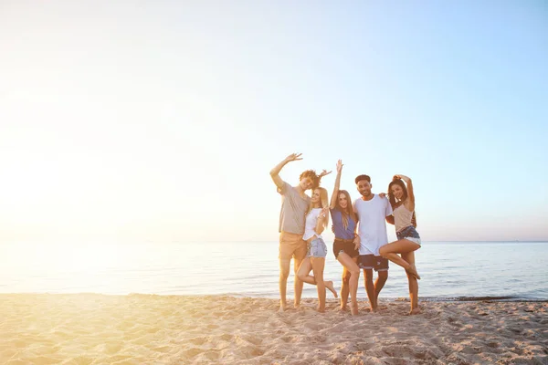 Grupo de amigos felices divirtiéndose en la playa del océano al amanecer — Foto de Stock