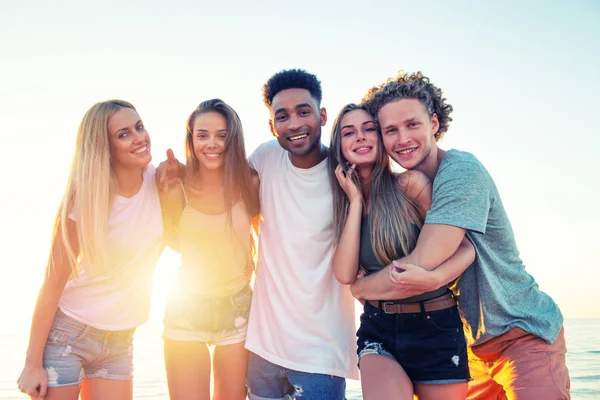 Grupo de amigos felizes se divertindo na praia do oceano ao amanhecer — Fotografia de Stock