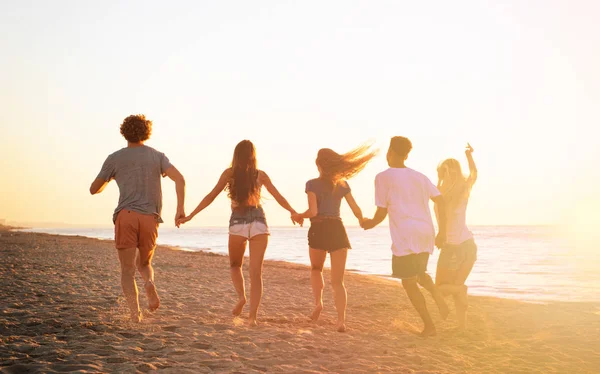 Un grupo de amigos corre en el mar. Concepto de verano — Foto de Stock