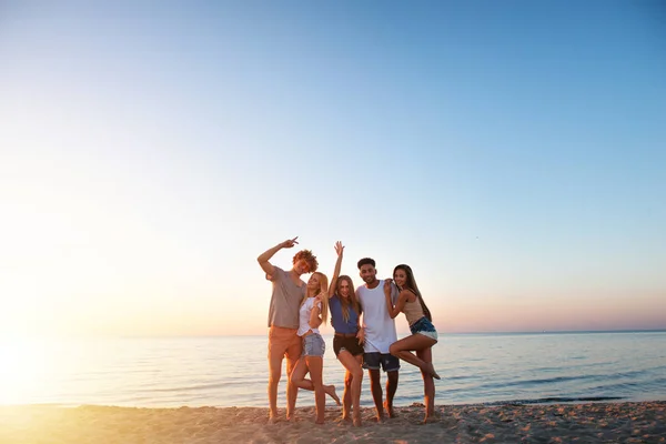 Grupa przyjaciół happy, zabawy na plaży oceanu o świcie — Zdjęcie stockowe