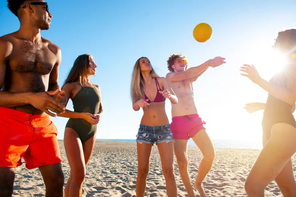 Grupo de amigos jugando al voleibol en la playa — Foto de Stock